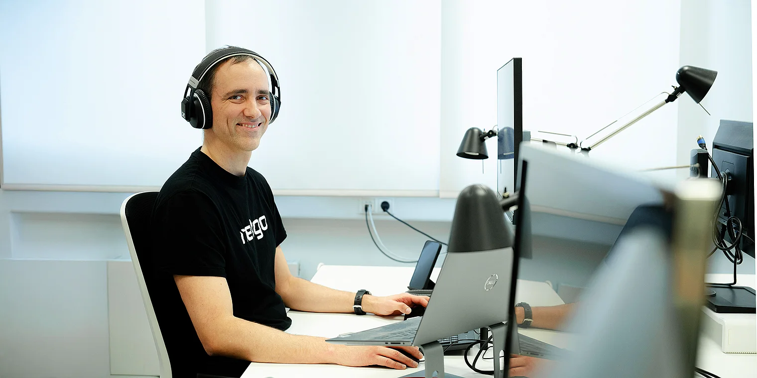 Claudio arbeitet konzentriert und repräsentiert die Arbeitsweise der Netigo GmbH; das Bild zeigt ihn in einem modernen Agenturumfeld mit visuellen Elementen, die Zusammenarbeit, Struktur und effiziente digitale Projektprozesse symbolisieren.