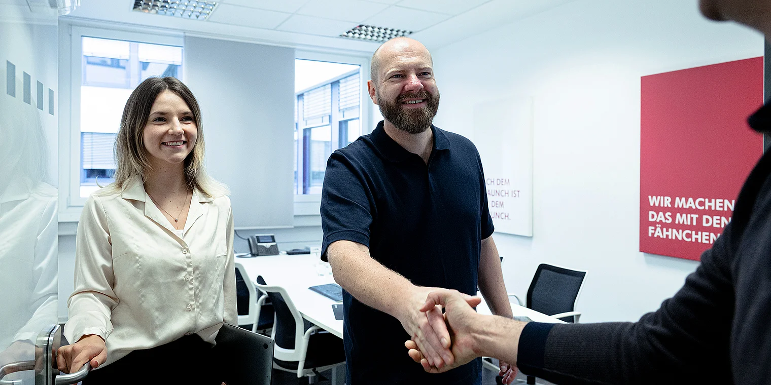 Geschäftsführer Martin Widemann und Melissa stehen nebeneinander und repräsentieren die Kunden- und Agentur-Leistungen der Netigo GmbH; das Bild vermittelt Professionalität und Kundenorientierung in einer modernen Agenturumgebung.